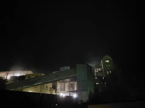 Vykládka v noci, prach v svetle reflektorov