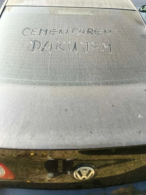 Nápis v prachu na skle auta